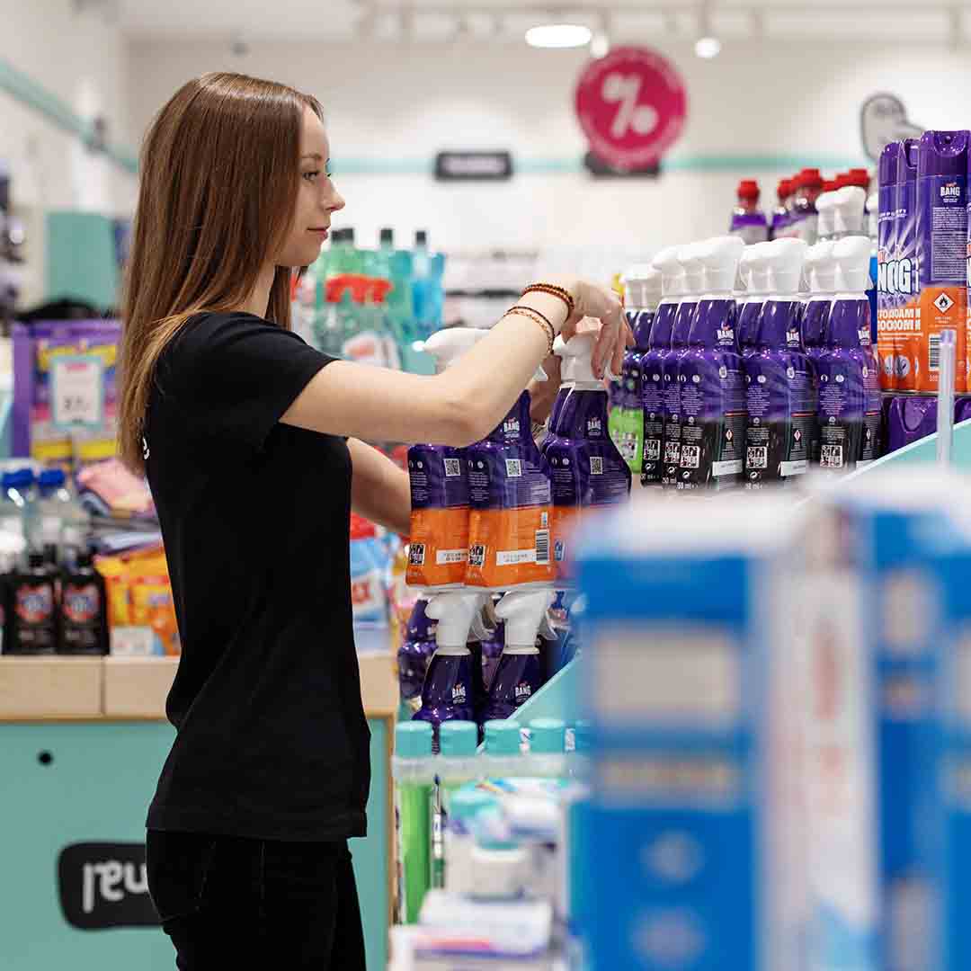 Employee from Normal in Frederiksberg standing by cleaning products.